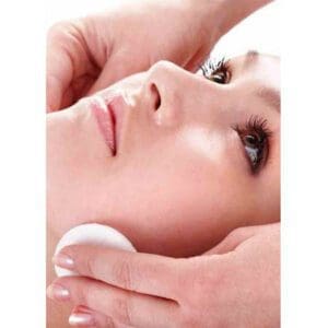 A person receiving a gentle facial cleansing treatment.
